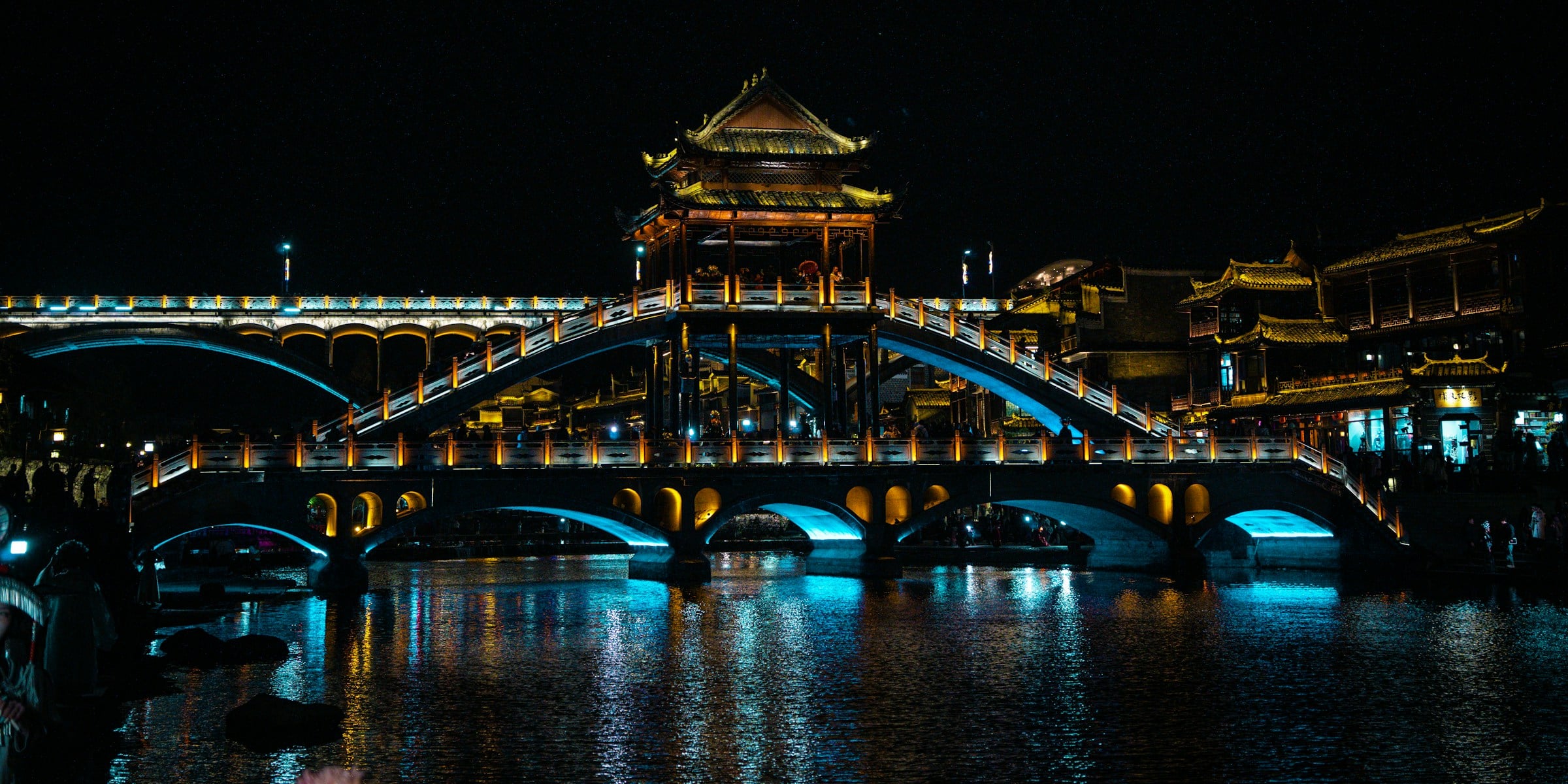 Ponte iluminada sobre o rio em Fenghuang