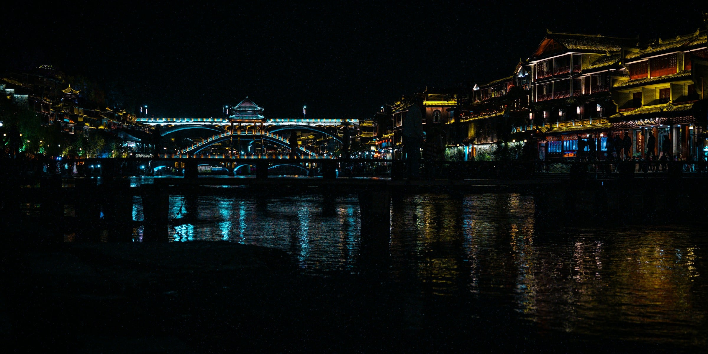 Luzes de Fenghuang refletidas no rio à noite